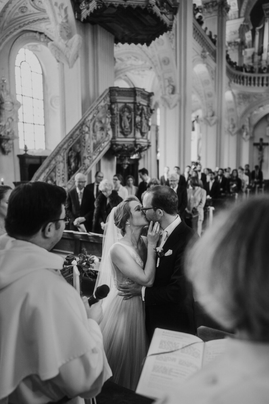 Hochzeitsbild von einer Hochzeit in der St.Andreas Kirche in Düsseldorf, das Brautpaar küsst sich.